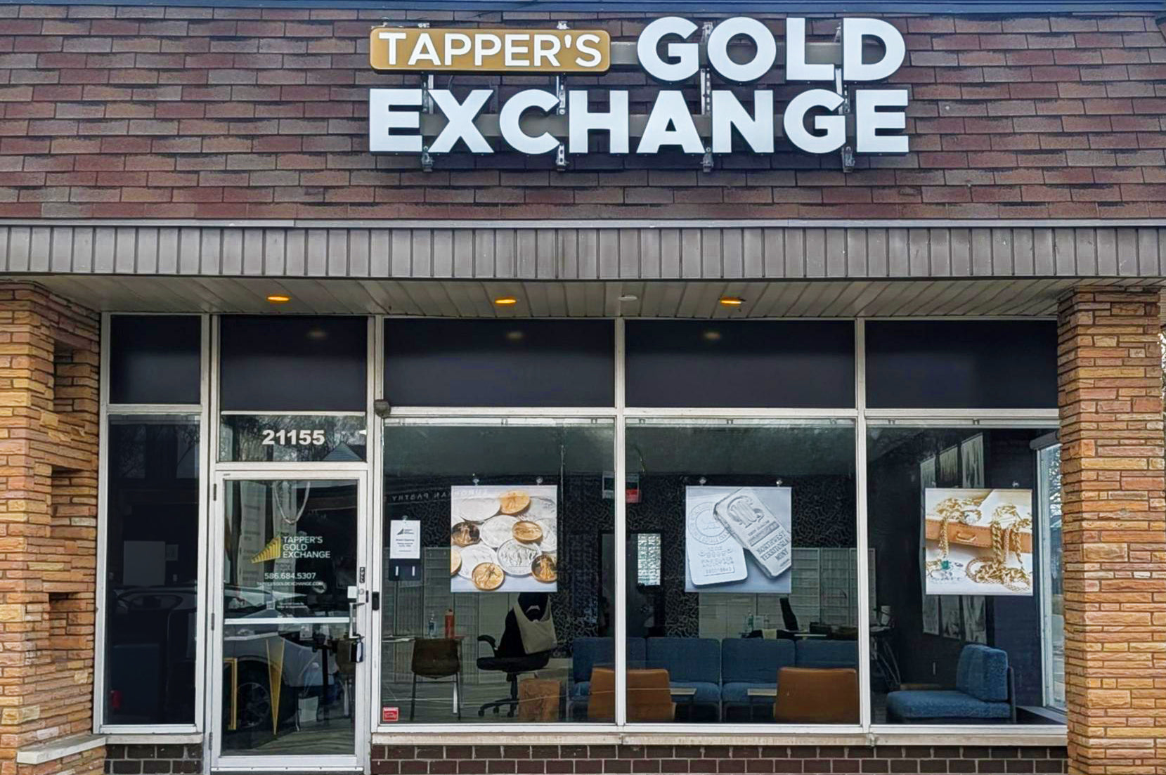 Storefront of Tapper's Gold Exchange with brick facade and glass windows.