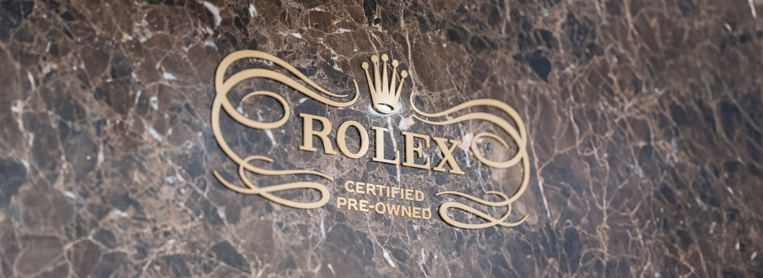 Rolex Certified Pre-Owned logo engraved in gold on marble surface