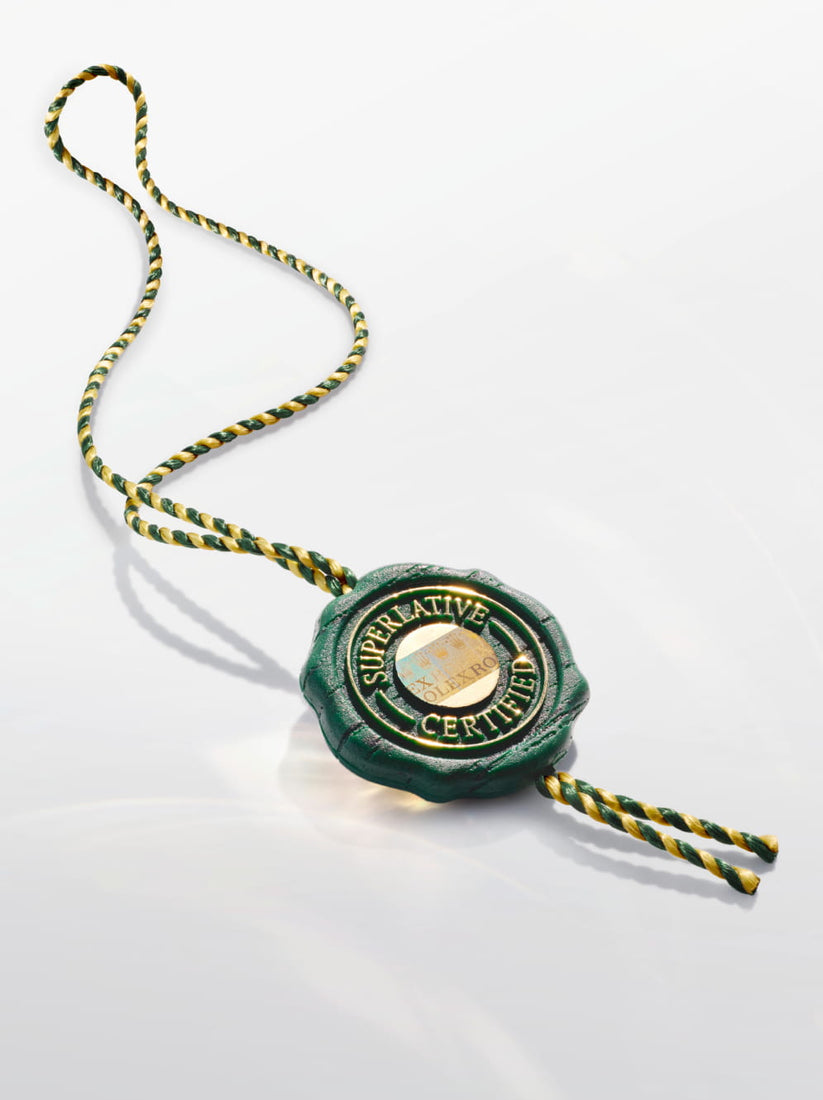 Green wax seal with gold accents on a white background
